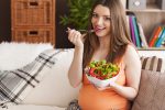 pregnant smiling woman eating salad How to boost your immunity during pregnancy