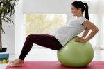 side view young pregnant woman exercising fitness ball Comfortable and Chic: Best Maternity Activewear for Active Moms-to-Be